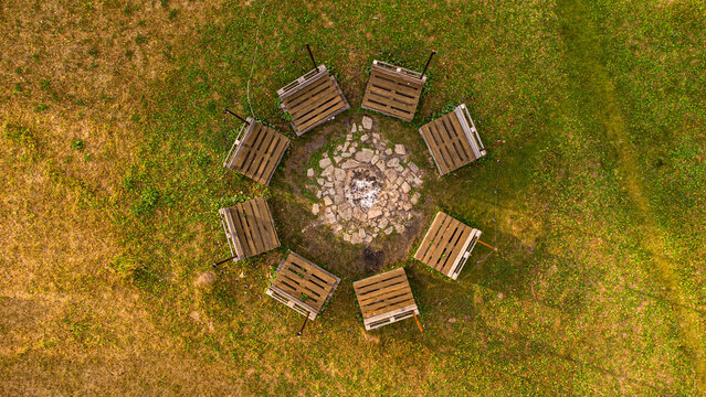 Aerial top view of picnic area with wooden benches and fire pit
