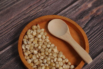 Dried Corn Kernels in Wooden Bowl with Spoon on Rustic Table Background