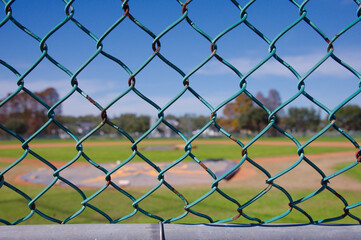 Fototapeta premium Baseball Field With Dugout, Fencing, and Green Grass Under Clear Blue Sky, Sunny Park. Crescent Lake Park old Spring Training facility St. Petersburg, FL. Historic 