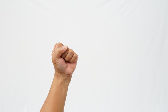A clenched left-hand fist raised against a solid white background. Symbolizing strength, power, and unity. High-quality stock photo for concepts of protest or grit