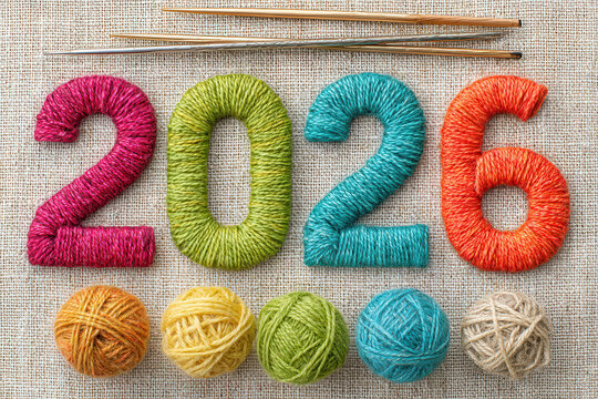 Colorful yarn forming the year 2026 with knitting tools and threads