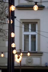 Historic facade dominates. Ornate window rises. Decorative stucco surrounds. Festive lights glow. © VladyslavShcherbakov