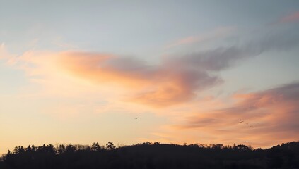 Obraz premium Serene Sunset Over Mountainous Landscape with Colorful Sky and Clouds