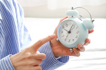 時計を指差す女性