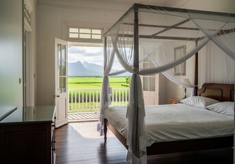 Naklejka premium Colonial style bedroom interior with canopy bed and open door view to green fields and mountains