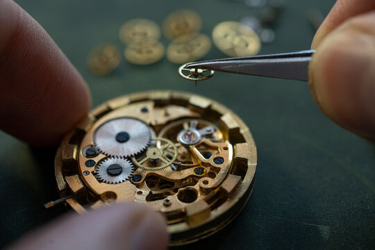 Closeup image of a watchmaker's workshop with dissembled watches and tools