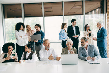 Professional team collaborating in a modern office, exchanging ideas during a business meeting for...