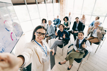 Business coach leading a creative workshop in a bright conference room with a diverse and enthusiastic professional team.