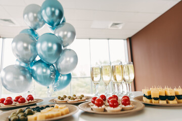 Office gathering with chic appetizers, champagne glasses, and festive balloon decorations...