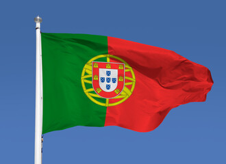 Close-up view of Portugal national flag waving in the wind. Portugal is an European country located in western Europe. Blue  sky background