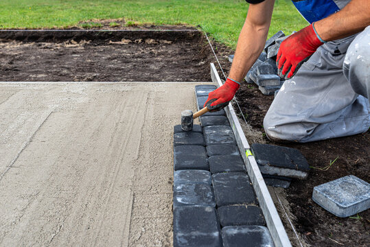Laying paving stones in the garden for a large expansion pool.