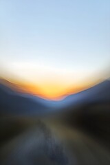 Blurred sunrise over abstract landscape with warm orange glow