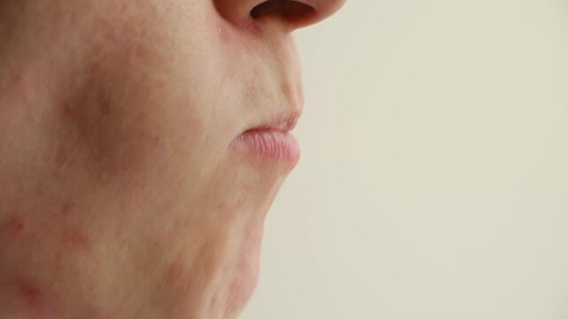 Close up side view of adult woman mouth, she eats fresh, juicy slice of mandarin orange, promoting healthy eating habits and enjoying natural vitamin c snack. Woman eating a slice of mandarin orange
