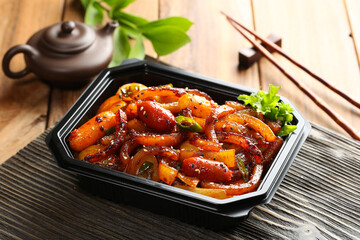 Spicy grilled pork skin packed in a delivery container. A popular Korean street food and drinking...
