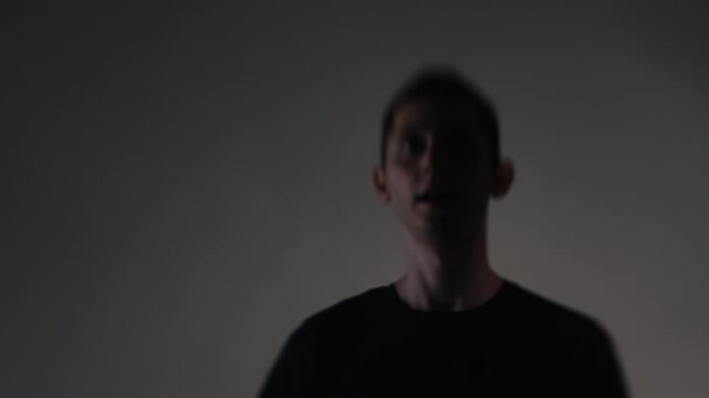 A young man in a frenzied state screams aggressively into the frame as a rock singer. Motion smear conveys his unstable, emotionally charged performance.