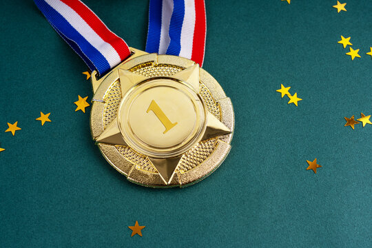 Gold medal with confetti on green background high angle view