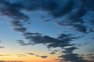 Obraz premium Breathtaking sunset sky with dramatic dark and golden cloud formations.
