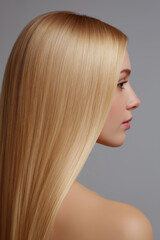 Fototapeta premium Beautiful blonde woman with long, straight, healthy hair in profile view