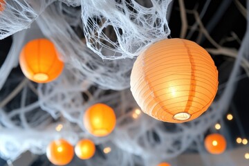 Obraz premium Enchanting orange lanterns on mystical tree branches with soft blue background