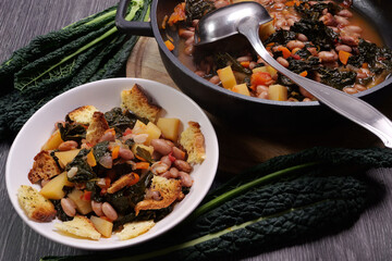 Piatto con zuppa di cavolo nero, patate e fagioli, con pane tostato