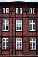 Fototapeta premium Red brick facade with black timber frame and white windows, architectural pattern background