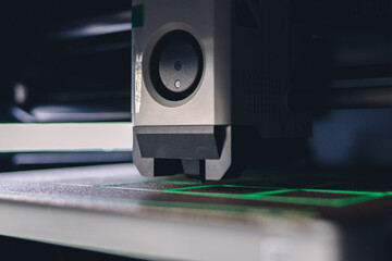 3d printer head printing plastic filament on a buildplate, marco, close up shot of process