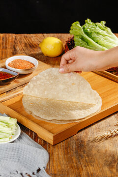Fresh Wheat Tortillas on Cutting Board with Ingredients for Homemade Burrito Making