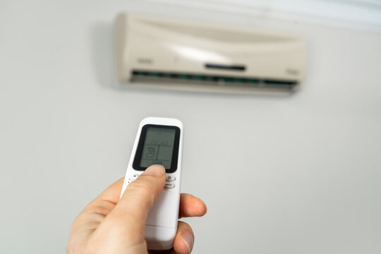 Hand Using Remote Control for Air Conditioner