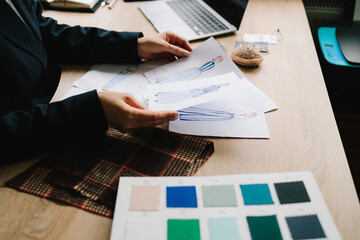 Designer maps dress designs on paper for precise garment planning.