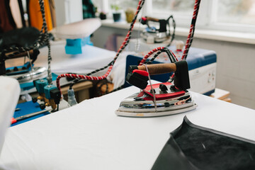 Designer uses industrial iron to smooth fabric for precise tailoring of apparel.