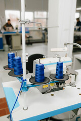 Spools of thread sit on sewing machine, ready for precise garment and apparel stitching.