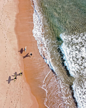 Aerial drone view sandy beach shore people walking waves Buzios Brazil coastal overhead

