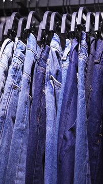 Denim jackets rack macro video of blue denim jackets hanging on a clothing rack in a retail store. Fashion retail display, casual wear collection, shopping and lifestyle concept.