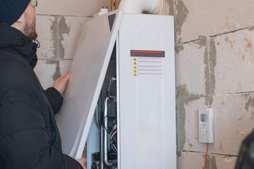A man checks the operation of a gas boiler.