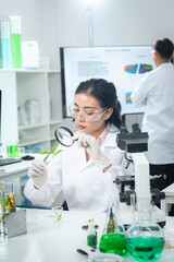 Fototapeta premium Scientist examining plant-based samples in a modern laboratory, representing sustainability, biotechnology, clean energy, and climate action concepts for ESG, green innovation, corporate communication