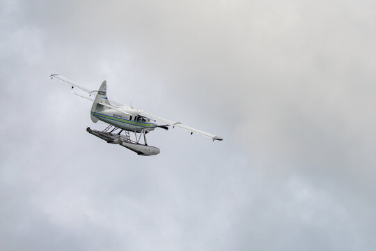 View of a seaplane gracefully soars against a backdrop of soft, diffused light, creating a sense of serene movement and adventure, Ketchikan, Alaska, United States.