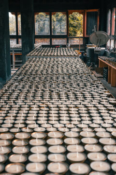 View of rows of candles stretch toward the light-filled windows, creating a serene and contemplative atmosphere, Jambay Lhakhang, Jakar, Bumthang, Bhutan.