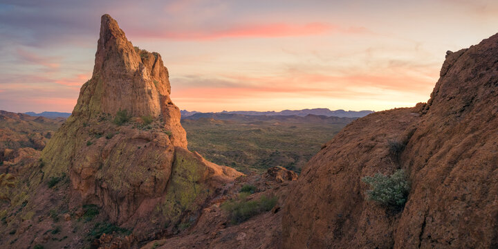 View of rugged desert landscape with sharp rock formations bathed in the warm glow of the setting sun, Yuma, Arizona, United States.