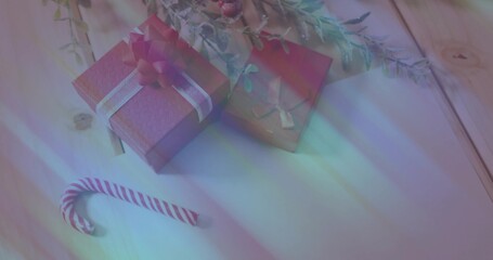 Displaying pair of wrapped gift boxes with kraft tag and candy cane on pale wooden tabletop