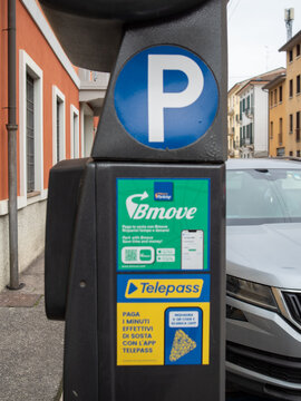 Parking meter showing QR codes and smartphone apps for convenient Bmove and Telepass mobile payments, modern urban parking
