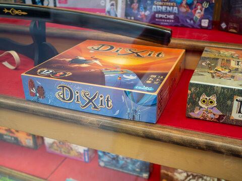 Dixit, Root and Sorcerer's Arena board games artfully arranged in a glass display case showcasing tabletop gaming collection