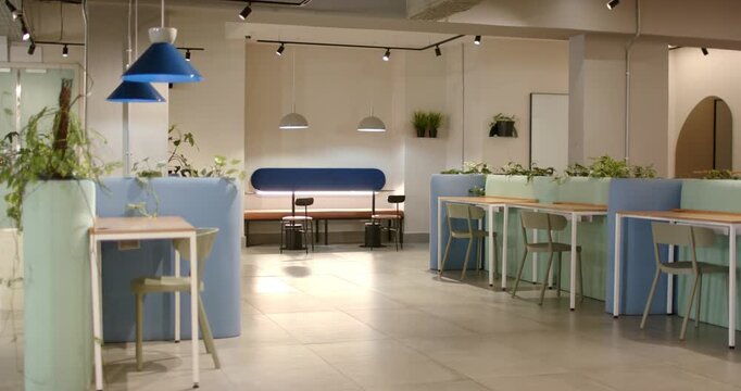 Camera is panning right showing bench lamps and plants in coworking lounge revealing seating