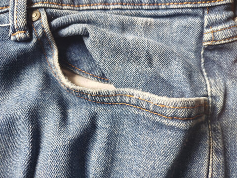 Detalle de bolsillo delantero y relojera en pantalones vaqueros azules con costuras