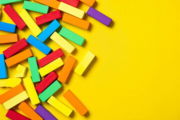 Colorful wooden blocks scattered on yellow surface for kids play and education  learning toys for children