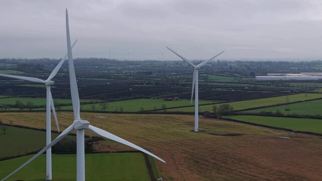 Aerial view of wind turbines piercing the sky, standing tall in the landscape, showcasing the blend of technology and nature, Yelvertoft, Crick, United Kingdom.