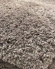 Close up of grey or beige textured deep pile carpet or rug