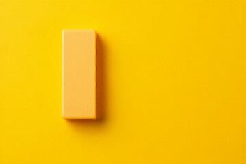 Yellow rectangular object on yellow background with shadow  simple still life composition