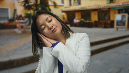 Fototapeta premium Woman outdoors on urban street in city center resting peacefully against stairs in casual wear.