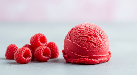 Vibrant raspberry sorbet scoop with fresh red berries on grey surface. Healthy fruit dessert photography with professional studio lighting