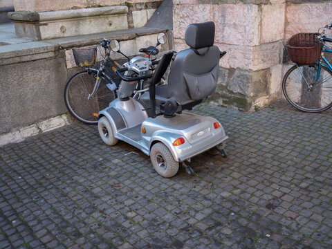 CTM HS 890 mobility scooter parked on a cobbled street with bicycles, highlighting personal freedom and accessible travel for people with disabilities